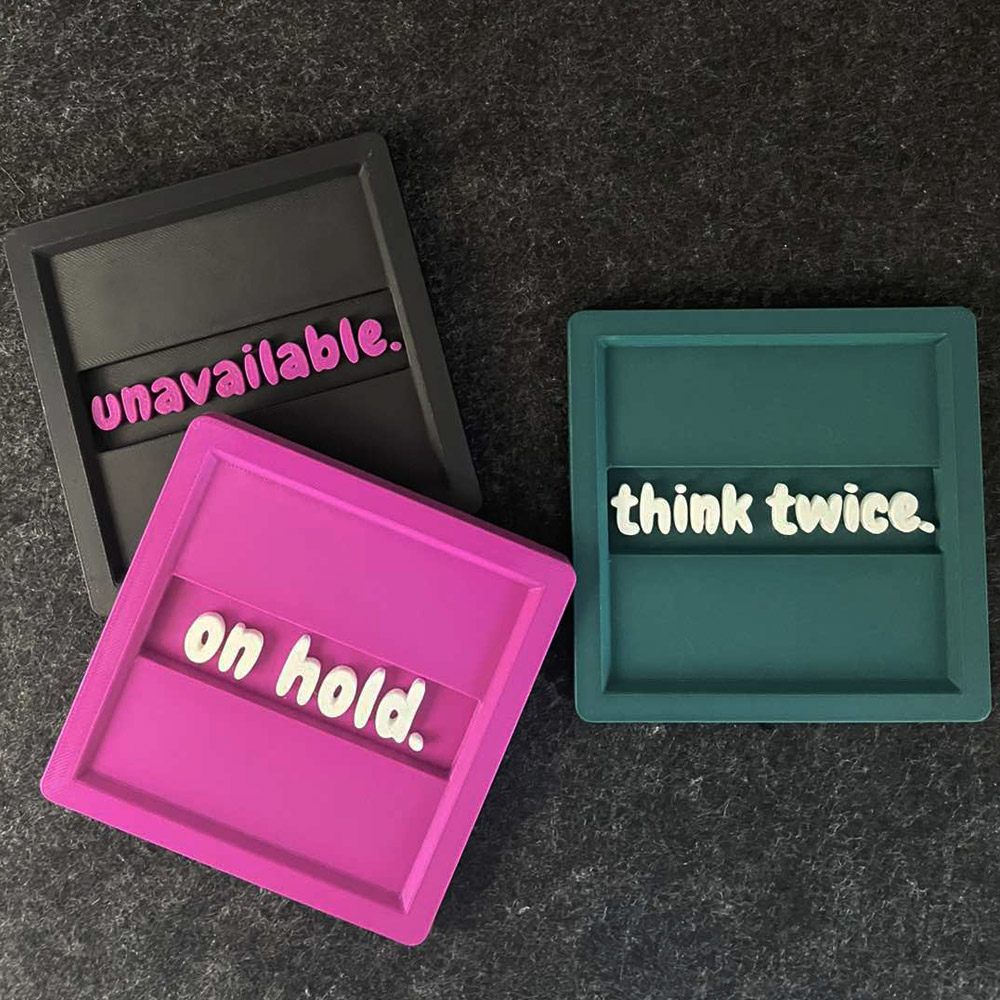 Τρία 3D printed σουβέρ με τις φράσεις “Unavailable”, “Think Twice” και “On Hold”, σχεδιασμένα για γραφείο και home office, που μπορούν να τοποθετηθούν και στον τοίχο.