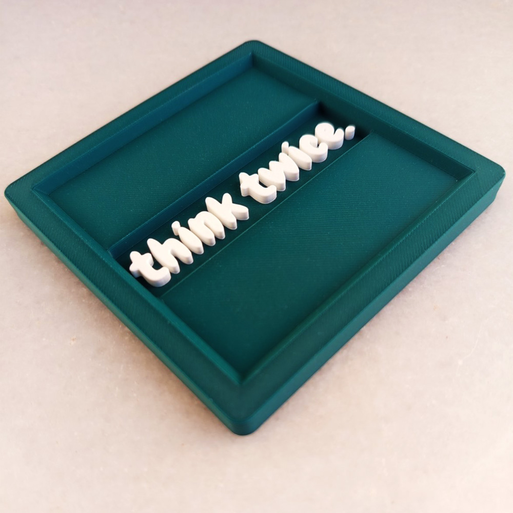3D Printed σουβέρ σε πράσινο Morandi με λευκά ανάγλυφα γράμματα.