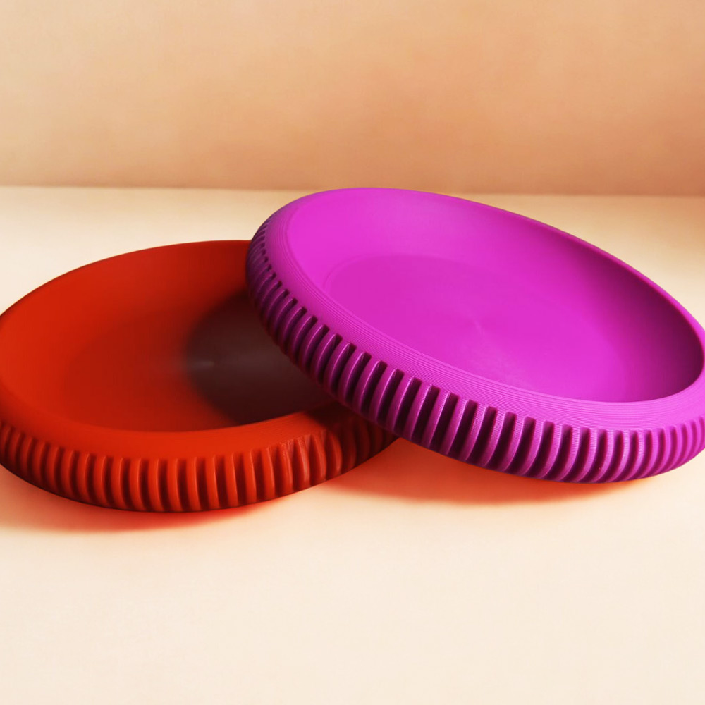 Δύο 3D printed δίσκοι οργάνωσης Ripple Tray σε κόκκινο και ματζέντα χρώμα.